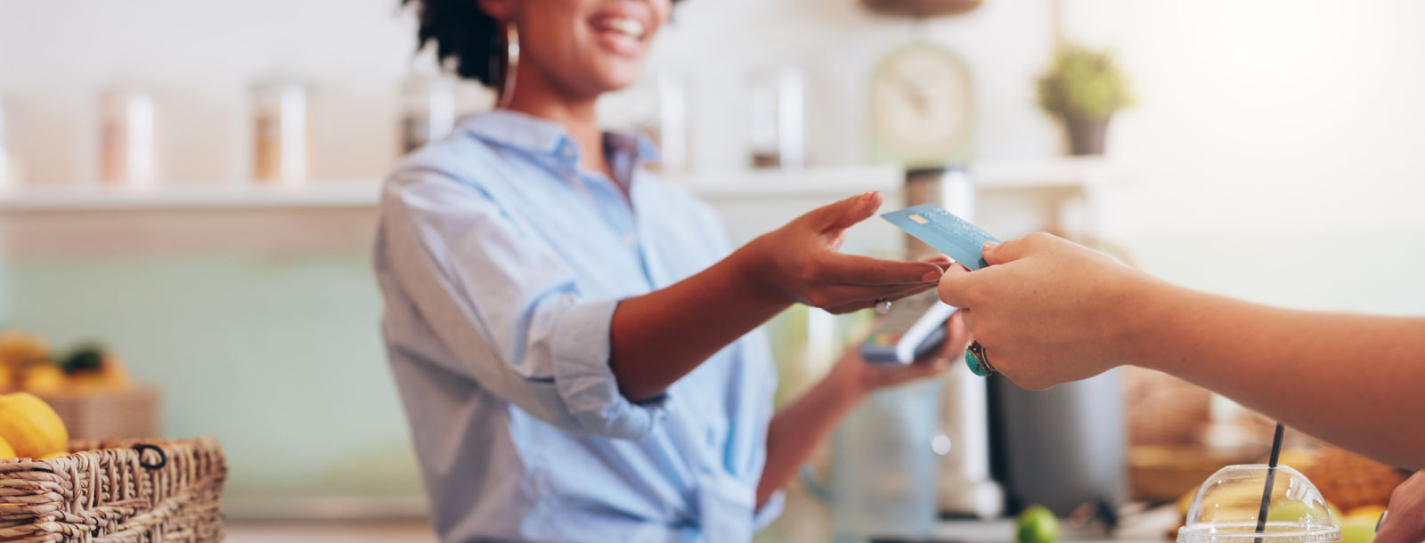 Close up of two people's hands exchanging a credit card