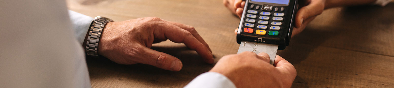 Close up of a person's hands paying with a credit card